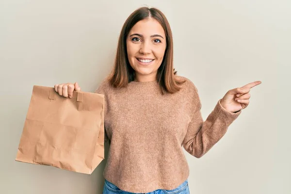 Ung Kaukasisk Kvinna Håller Bort Papperspåsen Ler Glad Och Positiv — Stockfoto