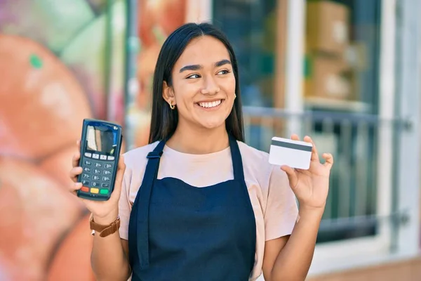 Joven Tendero Latino Sonriendo Feliz Sosteniendo Tarjeta Crédito Datáfono Tienda —  Fotos de Stock