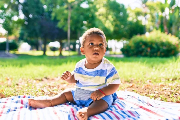 可敬的非洲裔美国幼儿坐在公园的草地上 — 图库照片