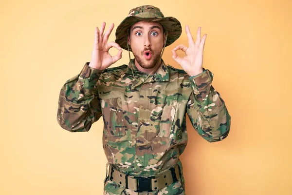 Joven Hombre Caucásico Vistiendo Uniforme Camuflaje Ejército Buscando Sorprendido Sorprendido —  Fotos de Stock