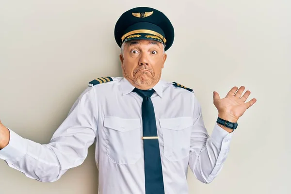 Schöner Mann Mittleren Alters Flugzeugpilotenuniform Ahnungslos Und Verwirrt Mit Erhobenen — Stockfoto