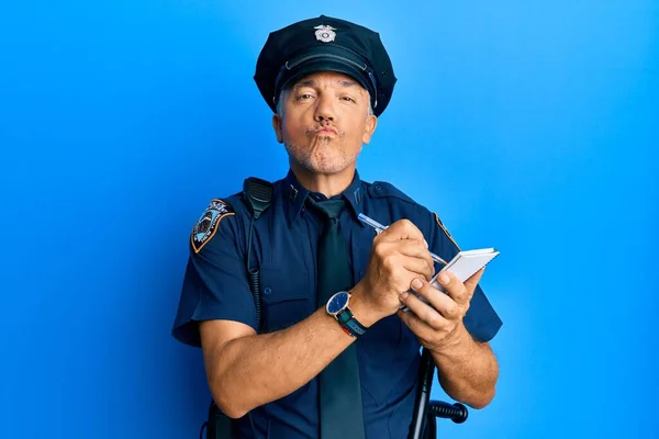 警察制服を着たハンサムな中年男性がカメラを見てチケットを書いてキスを吹いているのが可愛くてセクシー 愛の表現 — ストック写真