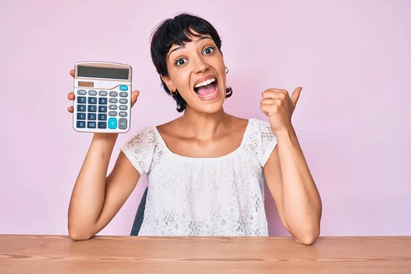 Mooie Brunettte Vrouw Tonen Rekenmachine Apparaat Duim Wijzen Naar Zijkant — Stockfoto