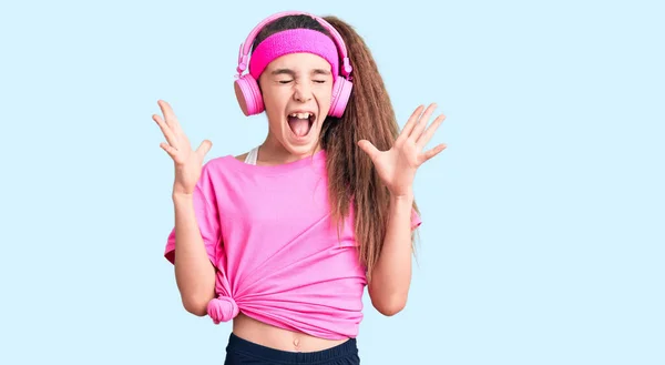 Χαριτωμένο Ισπανόφωνο Κορίτσι Φορώντας Ρούχα Γυμναστικής Και Χρησιμοποιώντας Ακουστικά Γιορτάζει — Φωτογραφία Αρχείου