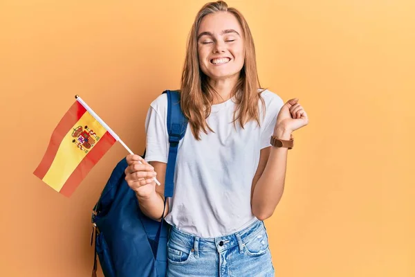 Hermosa Mujer Rubia Estudiante Intercambio Sosteniendo Bandera Española Gritando Orgullosa —  Fotos de Stock