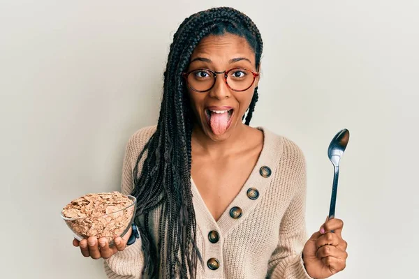 Afrykańska Amerykanka Warkoczami Jedząca Zdrowe Płatki Pełnoziarniste Wystające Języka Szczęśliwa — Zdjęcie stockowe