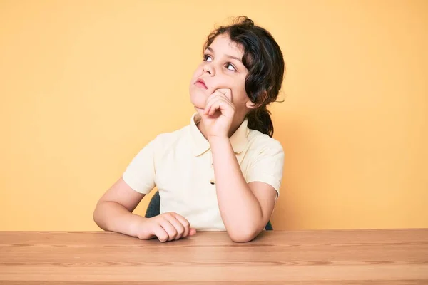 Tatlı Spanyol Çocuk Gündelik Giysiler Içinde Masada Oturuyor Ciddi Bir — Stok fotoğraf