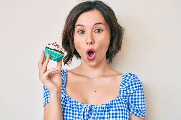 Νέα Όμορφη Γυναίκα Κρατώντας Cupcake Φοβάται Και Έκπληκτος Ανοιχτό Στόμα — Φωτογραφία Αρχείου