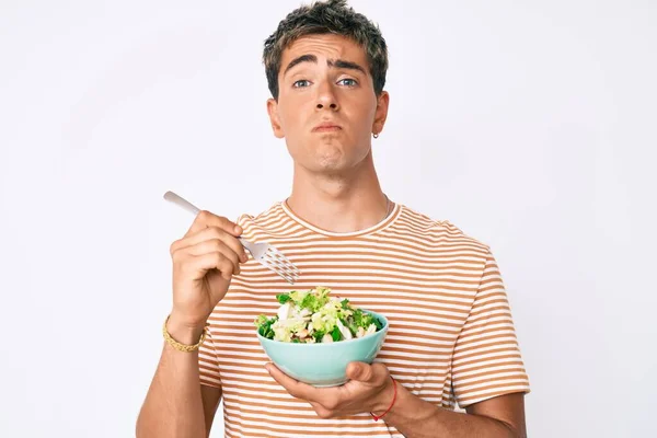 Young Handsome Man Eating Salad Puffing Cheeks Funny Face Mouth — Stock Photo, Image