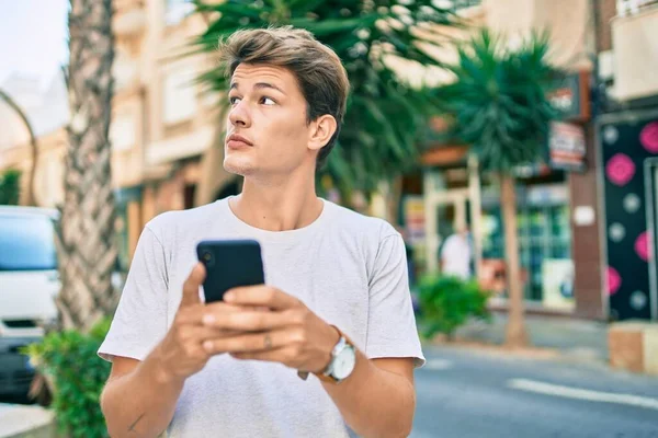 Jonge Kaukasische Man Met Serieuze Expressie Met Smartphone Stad — Stockfoto