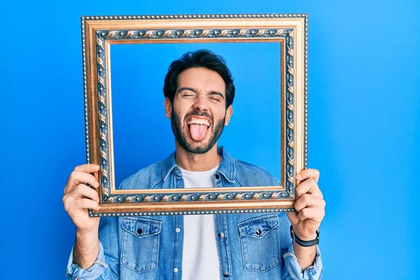 Ung Latinamerikansk Man Håller Tom Ram Sticker Tungan Glad Med — Stockfoto