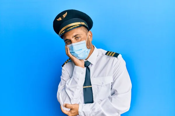 Jóképű Férfi Szakállas Pilóta Egyenruhát Visel Biztonsági Maszk Gondolkodás Fáradt — Stock Fotó