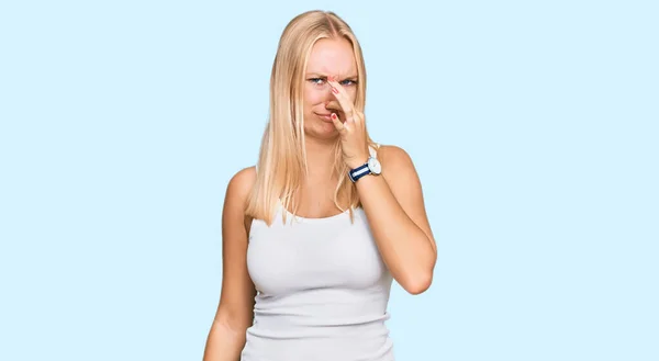 Young Blonde Girl Wearing Casual Style Sleeveless Shirt Smelling Something — Zdjęcie stockowe