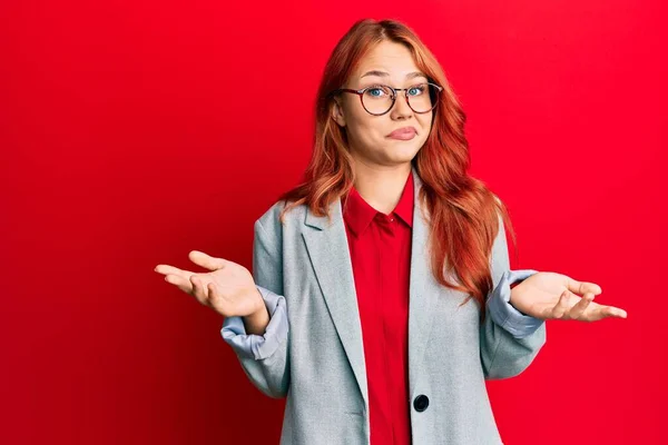 Fiatal Vörös Hajú Üzleti Kabátban Szemüvegben Tanácstalan Zavart Arckifejezéssel Felemelt — Stock Fotó