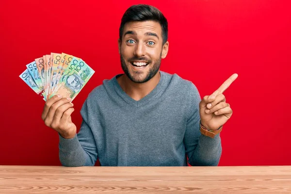 Hombre Hispano Guapo Sosteniendo Dólares Australianos Sonriendo Feliz Señalando Con —  Fotos de Stock