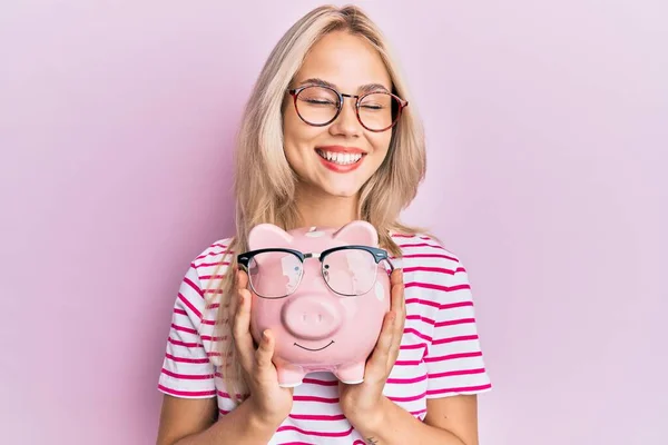 Mooi Blank Blond Meisje Holding Piggy Bank Met Bril Lachen — Stockfoto