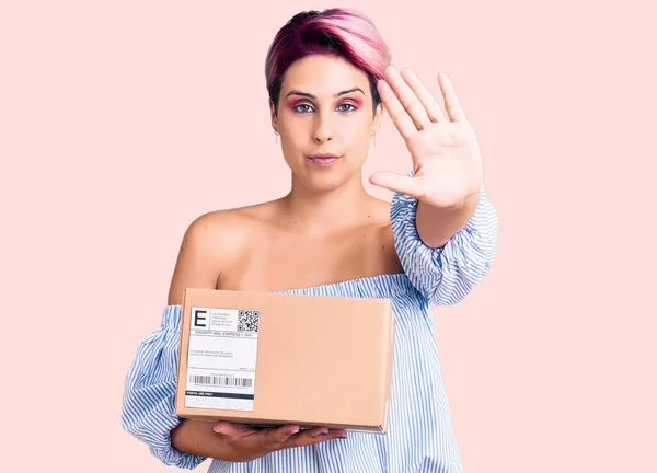 Młoda Piękna Kobieta Różowymi Włosami Trzymając Pakiet Dostawy Otwartą Ręką — Zdjęcie stockowe