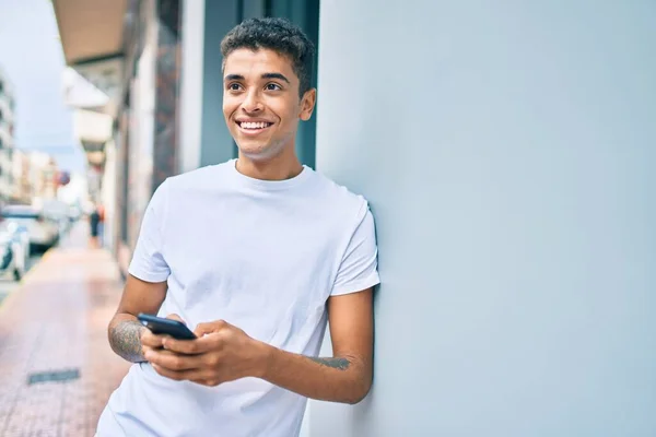 Jong Latijn Man Glimlachen Blij Met Behulp Van Smartphone Leunend — Stockfoto