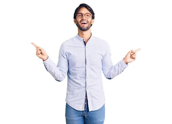 英俊而惊慌失措的男人穿着商务衬衫 戴着眼镜 带着自信的微笑 用手指指向不同的方向 复制广告空间 — 图库照片