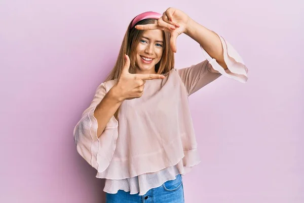カジュアルなシャツを着た美しい若いブロンドの女性と幸せな顔をした手と指でフレームを作るダイエム笑顔 創造性と写真の概念 — ストック写真