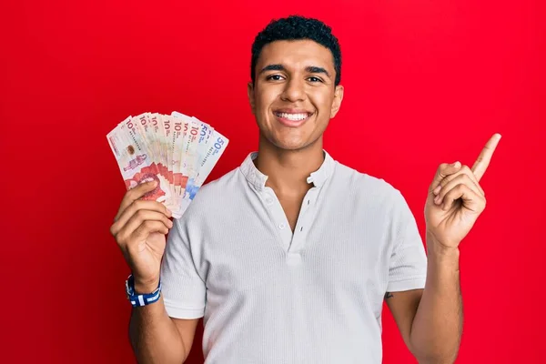 Joven Árabe Sosteniendo Pesos Colombianos Sonriendo Feliz Señalando Con Mano — Foto de Stock