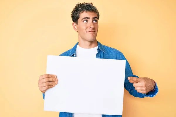 Joven Hombre Guapo Sosteniendo Pancarta Vacía Blanco Sonriendo Mirando Costado — Foto de Stock