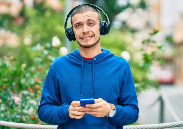 Jonge Spaanse Man Glimlacht Gelukkig Met Behulp Van Smartphone Koptelefoon — Stockfoto