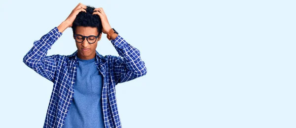 年轻的非洲裔美国男人穿着休闲装 戴着眼镜 由于疼痛和偏头痛 绝望和压力重重 手放在头上 — 图库照片