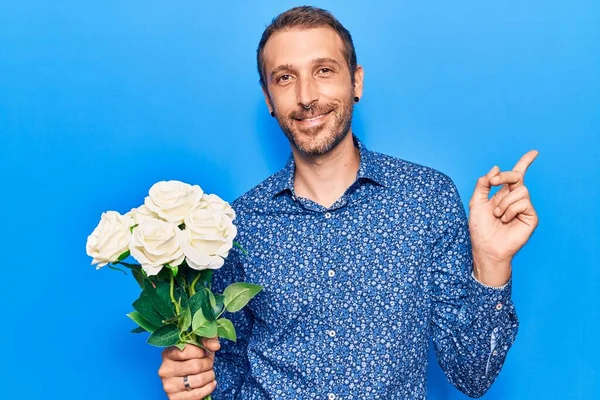 Young Handsome Man Holding Flowers Smiling Happy Pointing Hand Finger — Stock Photo, Image