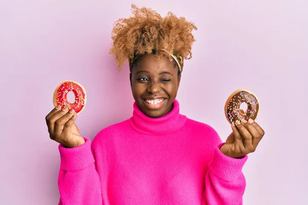 Junge Afrikanerin Mit Afro Haaren Hält Leckere Bunte Donuts Zwinkernd — Stockfoto