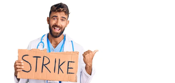 Jovem Hispânico Vestindo Estetoscópio Médico Segurando Banner Greve Apontando Polegar — Fotografia de Stock