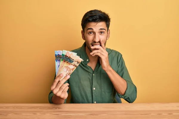 Joven Hombre Guapo Sosteniendo Dólares Canadienses Riendo Riéndose Avergonzado Cubriendo —  Fotos de Stock