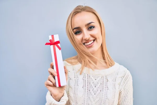 Joven Chica Rubia Sonriendo Feliz Sosteniendo Regalo Pie Ciudad —  Fotos de Stock