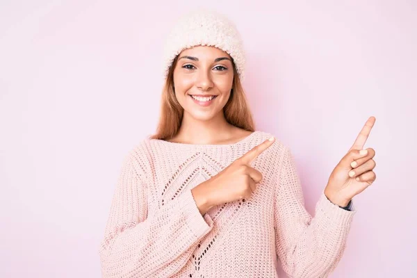 Młoda Brunetka Zimowym Kapeluszu Swetrze Uśmiechnięta Patrząca Kamerę Dwoma Rękami — Zdjęcie stockowe