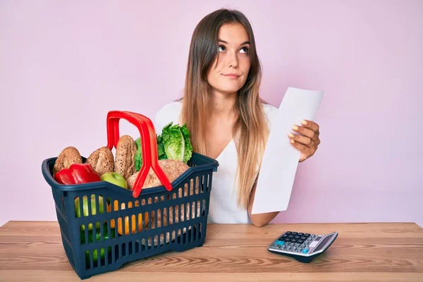 Beautiful Caucasian Woman Holding Supermarket Basket Groceries List Smiling Looking — Stock Photo, Image