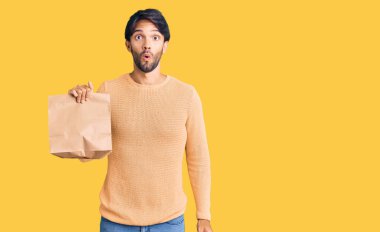 Yakışıklı İspanyol adam, paket kağıdı alıp götürürken ağzı açık kalmış, korkmuş ve hayrete düşmüş. 