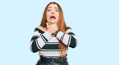 Güzel, kızıl saçlı, zarif kıyafetler giymiş genç bir kadın bağırıyor ve boğuluyor çünkü acı verici bir şekilde boğuluyor. Sağlık problemi. Boğulma ve intihar konsepti. 