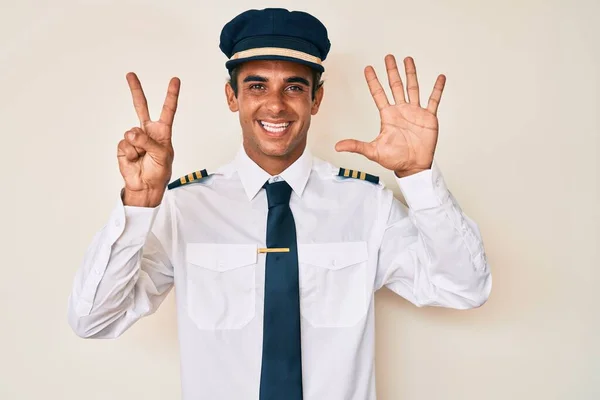 Junger Hispanischer Mann Flugzeugpilotenuniform Zeigt Mit Finger Nummer Sieben Nach — Stockfoto