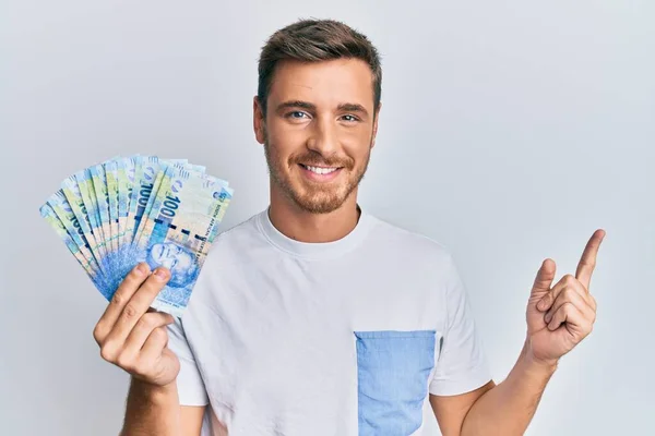 Hombre Caucásico Guapo Sosteniendo Billetes Rand Sudafricanos Sonriendo Feliz Señalando —  Fotos de Stock