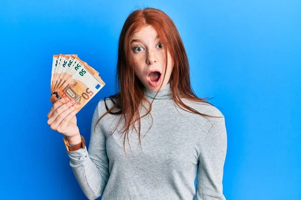 Joven Chica Pelirroja Sosteniendo Manojo Billetes Euros Asustado Sorprendido Con — Foto de Stock