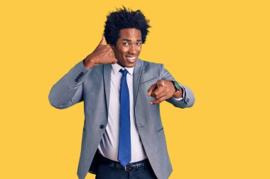 Afro saçlı, iş ceketi giymiş, gülümseyen, telefonda konuşan ve seni işaret eden yakışıklı Afro-Amerikalı adam. Ara beni.. 