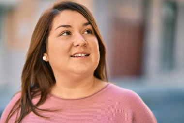 Genç İspanyol artı iri kadın gülümseyerek şehirde mutlu mesut dikiliyor..