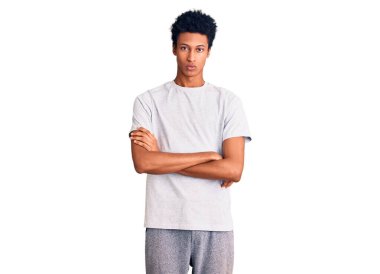Gündelik kıyafetler giyen, kuşkucu ve gergin genç Afro-Amerikalı bir adam. Yüzünde çapraz kollarla onaylamayan bir ifade var. negatif kişi. 