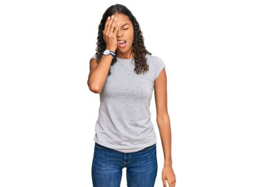 Genç Afro-Amerikan kızı günlük kıyafetler giyiyor. Yarı yüz, göz ve ağız kaplamasından yorgun düşüyor. Yüzüm acıyor.. 