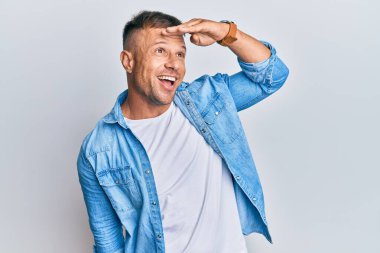 Yakışıklı, sıradan bir kot ceket giyen çok mutlu ve tebessüm eden kaslı bir adam. arama kavramı. 