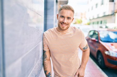 Genç İrlandalı gülümseyen mutlu adam şehrin duvarına yaslanıyor..