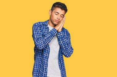 Genç, yakışıklı, Afro-Amerikalı, günlük kıyafetler giymiş, yorgun uyuyor, hayal kuruyor ve elleri ile poz veriyor, gözleri kapalı gülümsüyor.. 