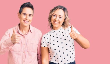 Neşeli ve pozitif gülümseyen, mükemmel ve onay işareti yapan bir çift kadın. 