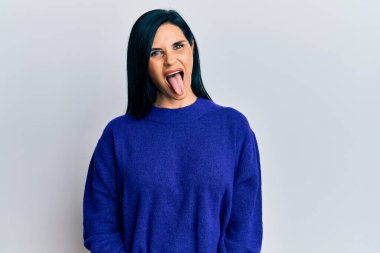 Günlük kıyafetler giyen beyaz bir kadın komik bir ifadeyle dilini dışarı çıkarıyor. duygu kavramı. 