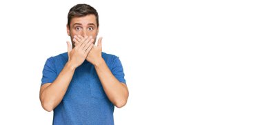 Sıradan kıyafetler giyen yakışıklı beyaz adam yanlışlıkla elleri ile ağzını kapatırken şok oldu. gizli kavram. 